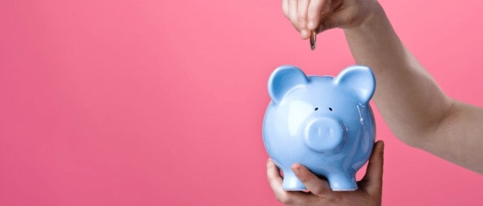 person saving money in piggy bank