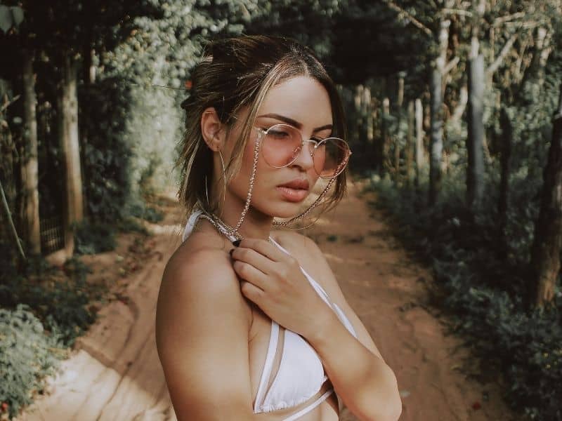 a woman wearing glasses in a forest