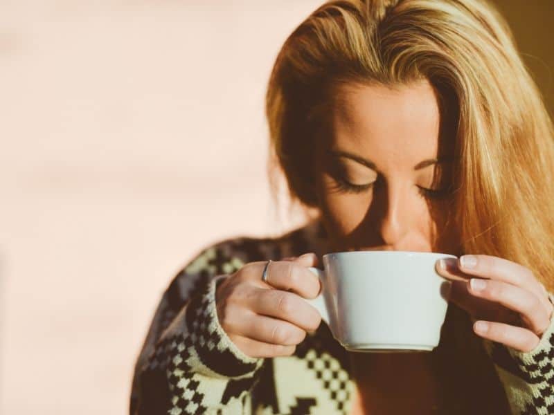 WOMAN DRINKING OUT OF A MUG