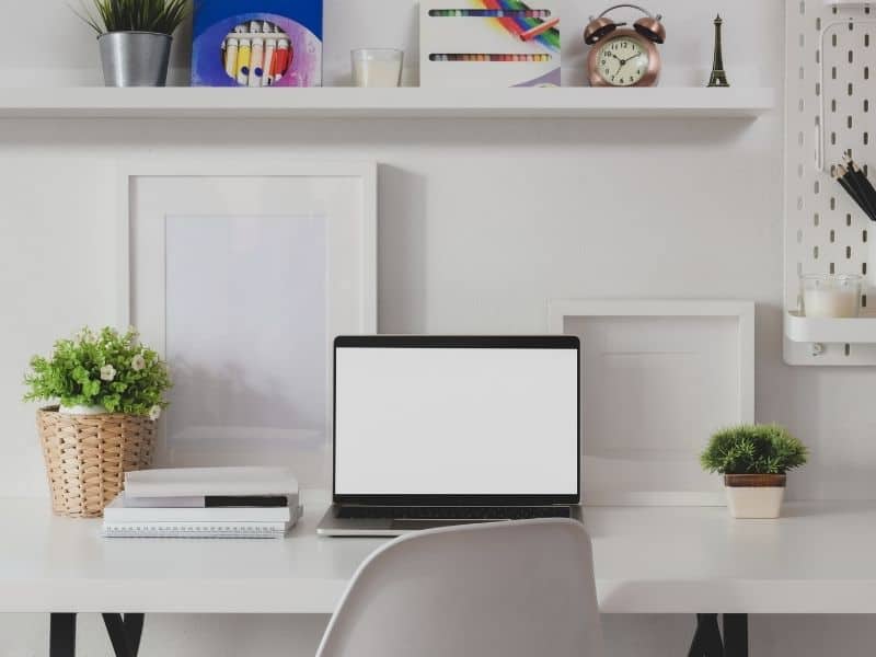 a laptop set up on an organized white desk