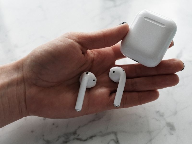 hands holding a pair of apple air pods