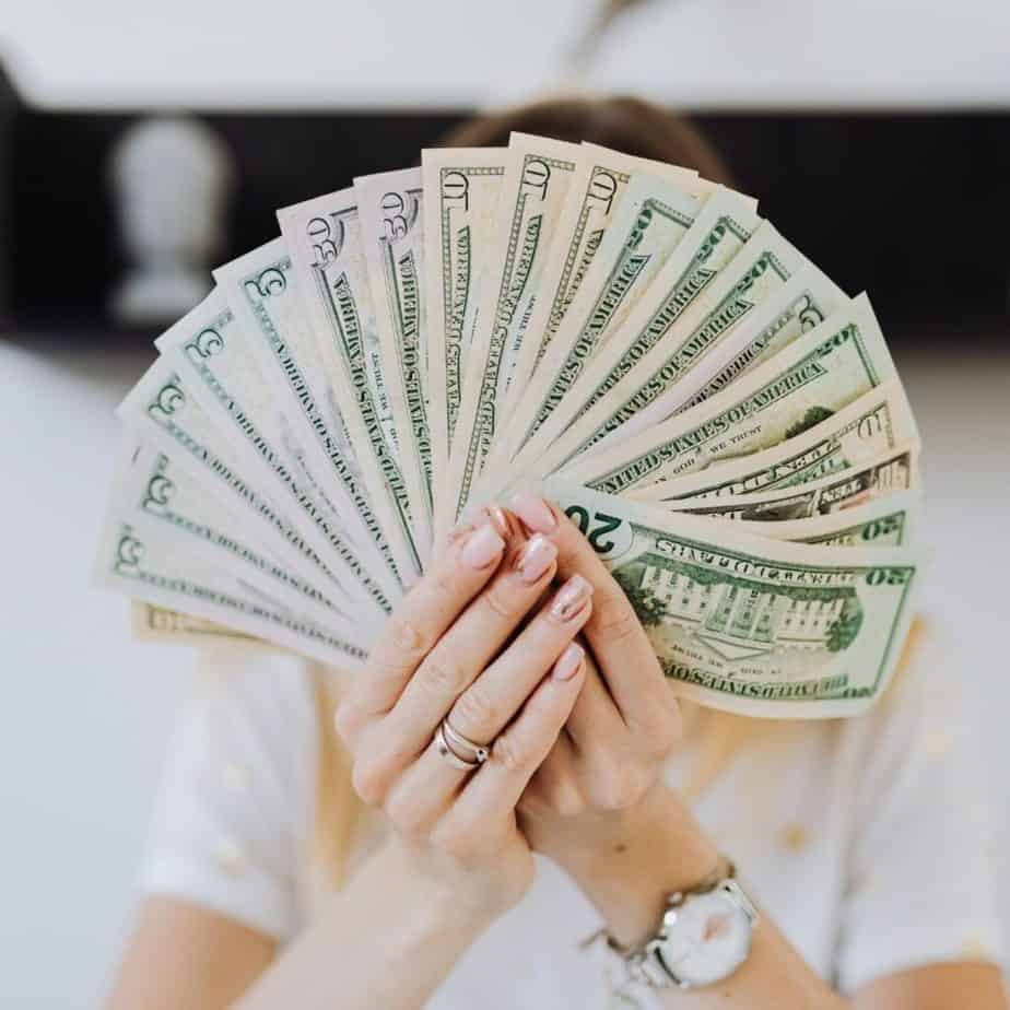 a woman fanning out money in front of her face
