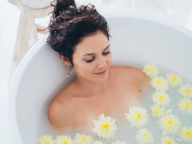 a woman in a bath with flowers in it