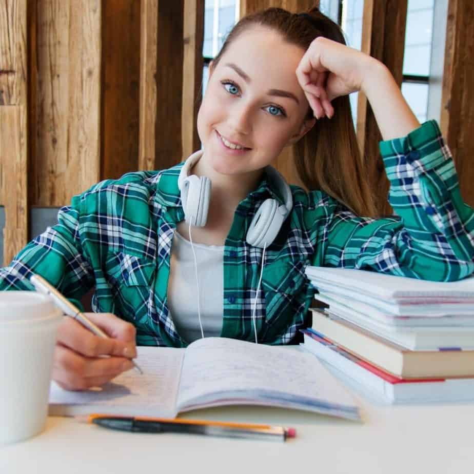a girl studying with a notebook and books in front of her