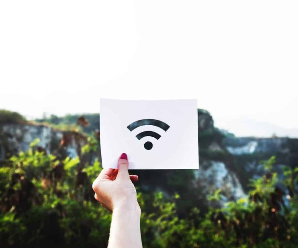 a hand holding up a paper with a wifi signal picture on it