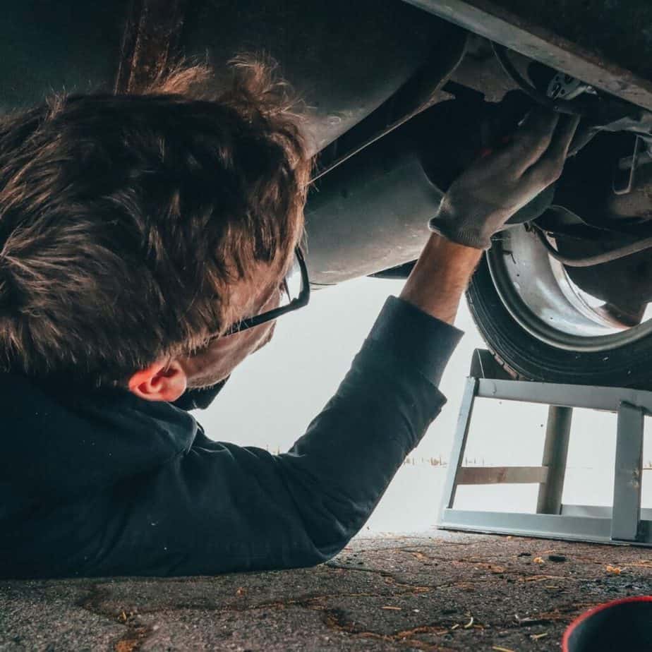 a mechanic under a car fixing it