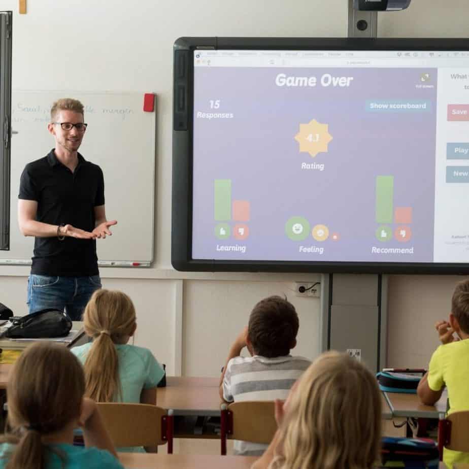 a teacher in front of a class showing a screen