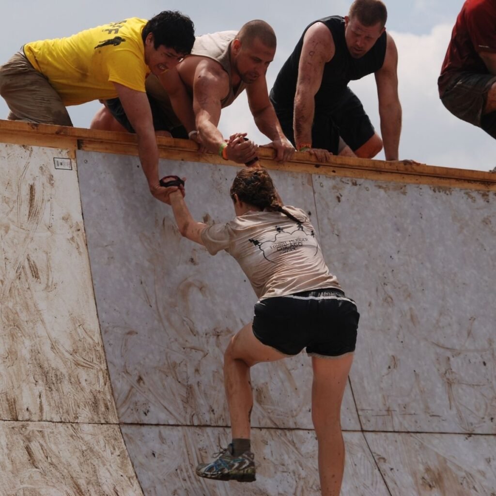 a woman being pulled up a wall by men