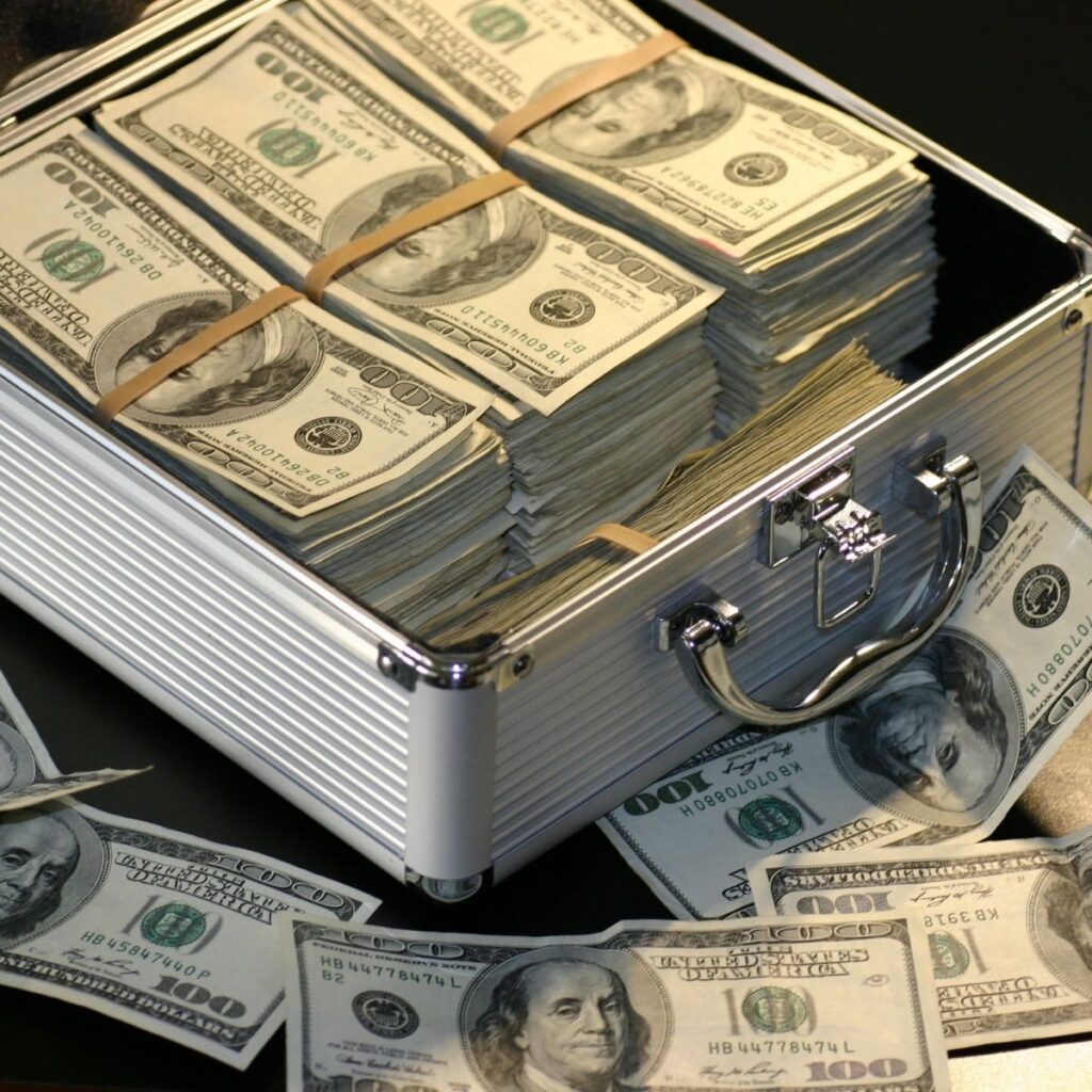 a box of $100 dollar bills and money spread around the outside