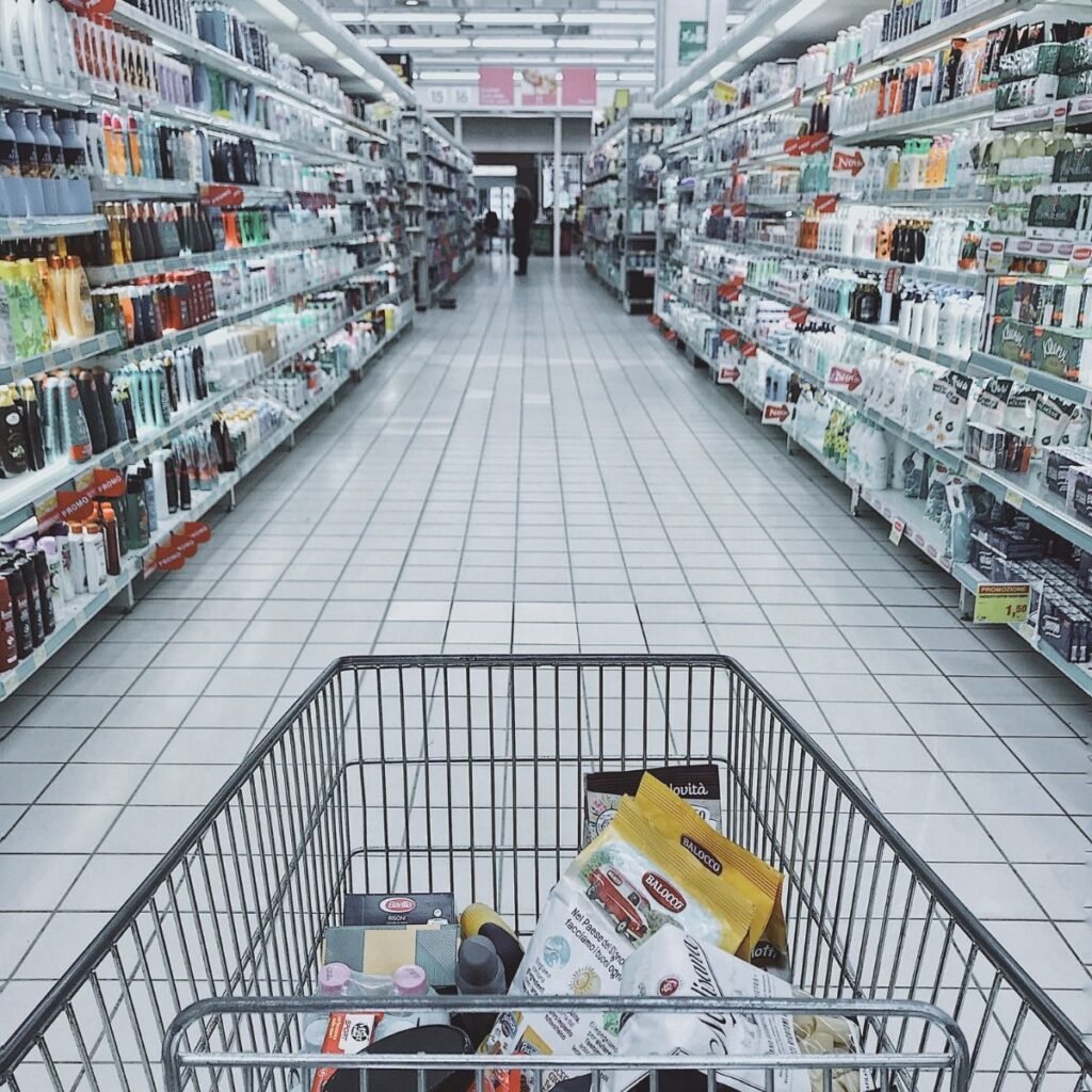 a grocery cart looking down the center of a grocery aisle