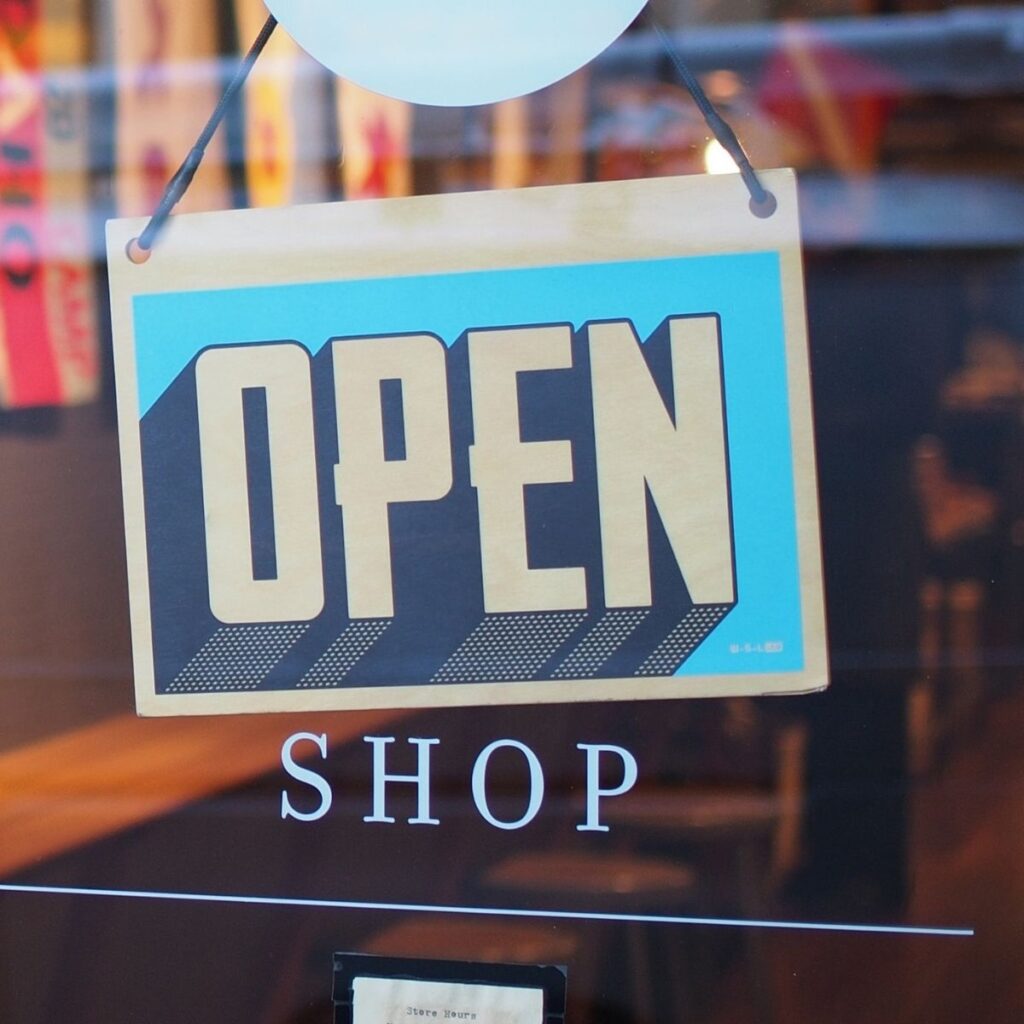 an open sign hanging on the door of a shop