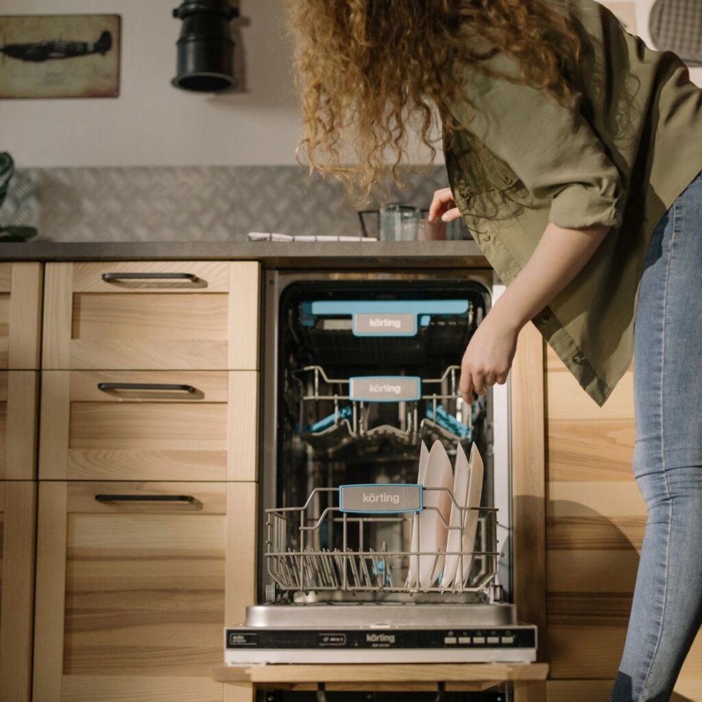 a woman putting dishes in a dishwasher