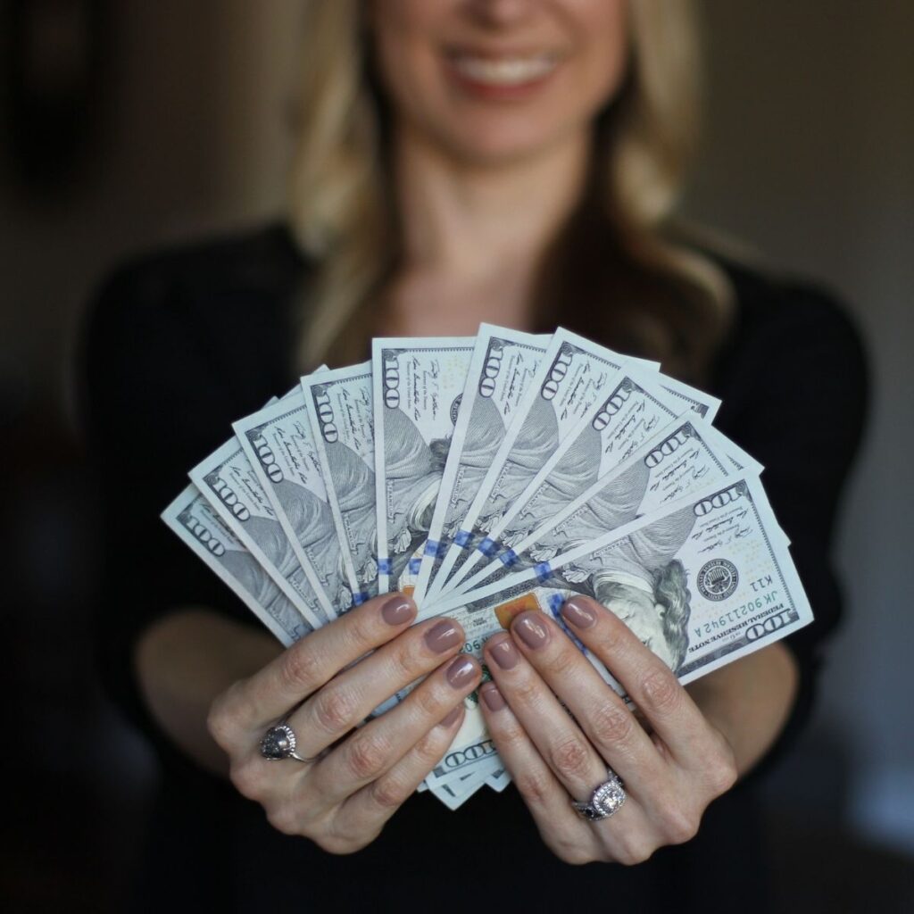 A woman fanning money in front of the camera