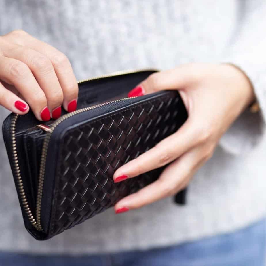 a woman opening a black wallet