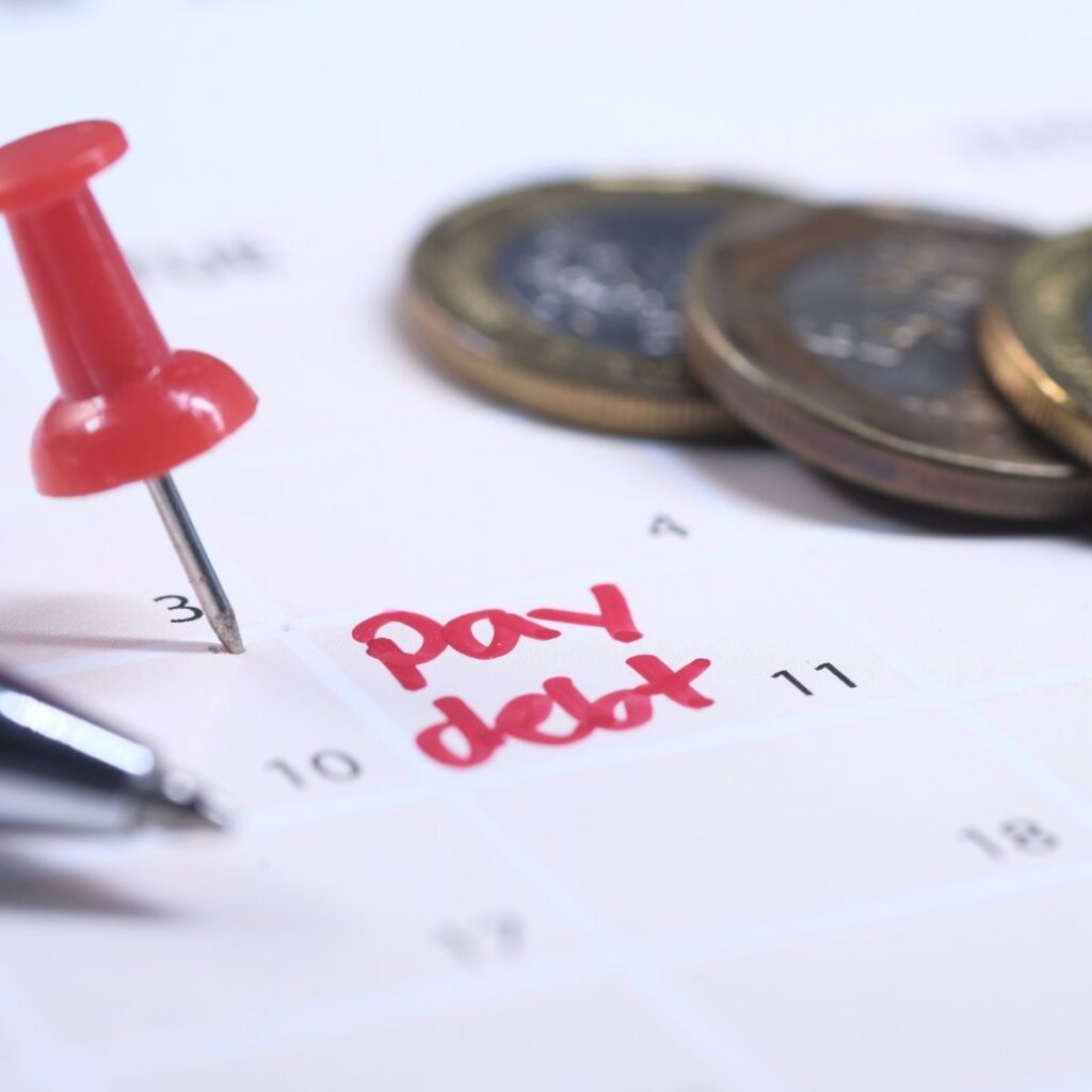a calendar with words "pay debt" in red